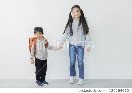 Elementary school student carrying a school bag 129264010