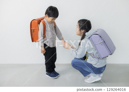 Elementary school student carrying a school bag Elementary school student carrying a school bag 129264016
