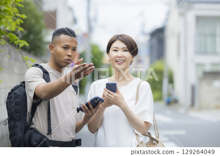 A woman explaining the way to a foreign man A woman explaining the way to a foreign man 129264049