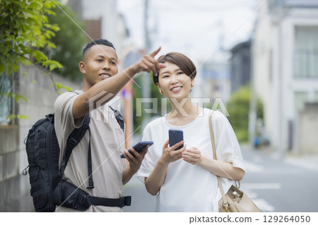 A woman explaining the way to a foreign man A woman explaining the way to a foreign man 129264050