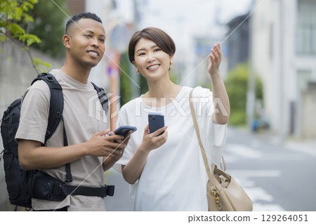 A woman explaining the way to a foreign man A woman explaining the way to a foreign man 129264051