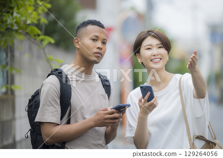 A woman explaining the way to a foreign man A woman explaining the way to a foreign man 129264056