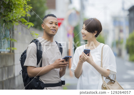 一名女子向一名外國男子講解道路 一名女子向一名外國男子講解道路 129264057