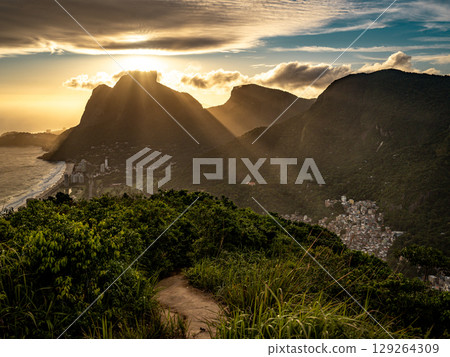 Golden Sunset Over Rio De Janeiro From Two Brothers Mountain: Dramatic Sunbeams Streaming Through Coastal Peaks Above The Atlantic Ocean And Leblon Beach 129264309
