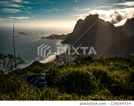 Golden Sunset Over Rio De Janeiro From Two Brothers Mountain: Dramatic Sunbeams Streaming Through Coastal Peaks Above The Atlantic Ocean And Leblon Beach Golden Sunset Over Rio De Janeiro From Two Brothers Mountain: Dramatic Sunbeams Streaming Through Coastal Peaks Above The Atlantic Ocean And Leblon Beach 129264314