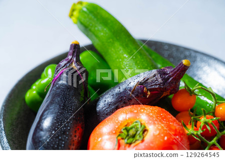 Assortment of fresh, dewy summer vegetables: tomatoes, eggplant, cucumbers, zucchini, and peppers Assortment of fresh, dewy summer vegetables: tomatoes, eggplant, cucumbers, zucchini, and peppers 129264545