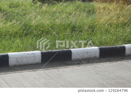 black and white curb road cement texture with green grass black and white curb road cement texture with green grass 129264796
