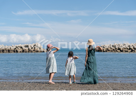 父母和孩子在海灘上丟石頭玩耍 129264908