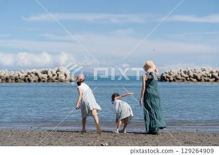 Parent and child playing on the sandy beach Parent and child playing on the sandy beach 129264909