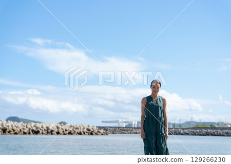 A young woman standing on the coast A young woman standing on the coast 129266230