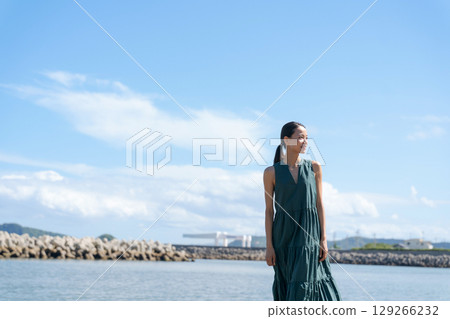 A young woman standing on the coast A young woman standing on the coast 129266232