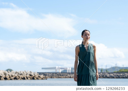 A young woman standing on the coast A young woman standing on the coast 129266233