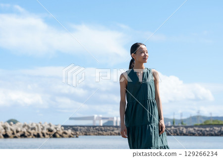 A young woman standing on the coast A young woman standing on the coast 129266234