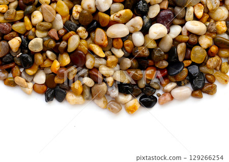Small colorful pebbles on a white background. Small colorful pebbles on a white background. 129266254