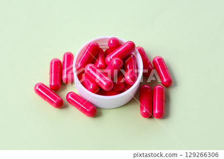 Red astaxanthin supplement capsules on a white background. 129266306