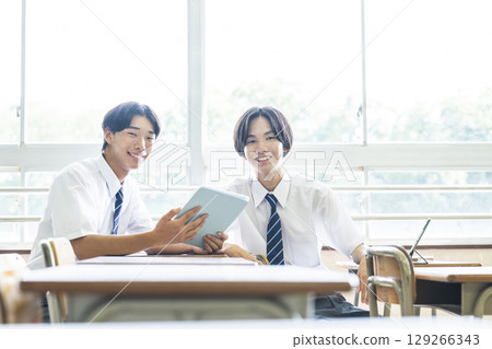 男國中生和朋友一起看平板電腦，看著鏡頭 129266343