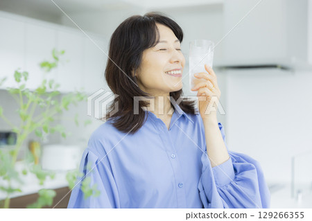 一個女人在廚房喝水 129266355