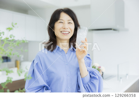 一個女人在廚房喝水 129266358
