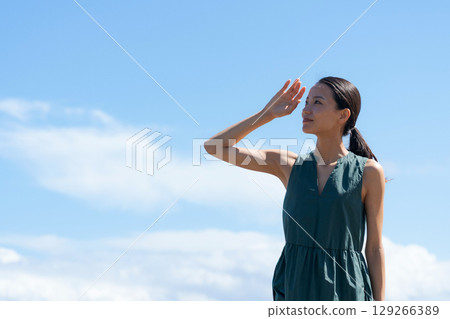 A young woman standing on the coast 129266389