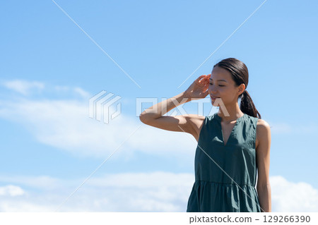 A young woman standing on the coast 129266390