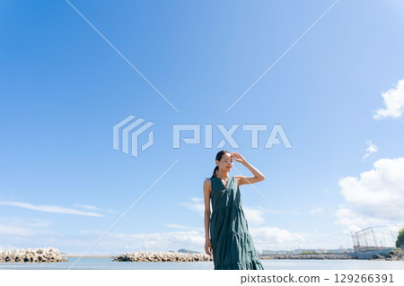 A young woman standing on the coast 129266391