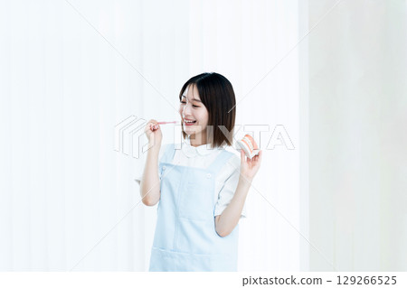 Female dental staff member giving tooth brushing instructions 129266525