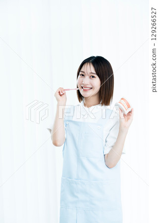 Female dental staff member giving tooth brushing instructions Female dental staff member giving tooth brushing instructions 129266527