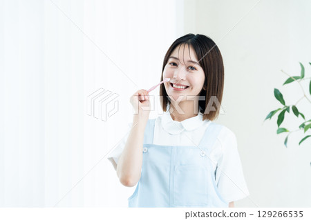 Female dental staff member giving tooth brushing instructions Female dental staff member giving tooth brushing instructions 129266535
