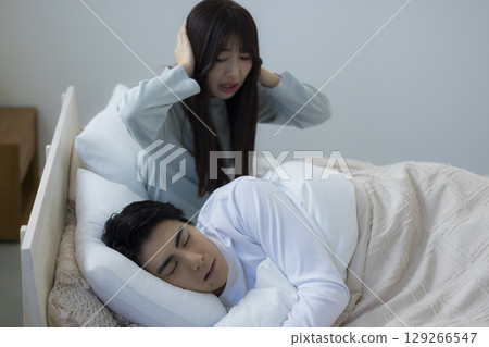 一個年輕人在床上睡覺打呼嚕 一個年輕人在床上睡覺打呼嚕 129266547