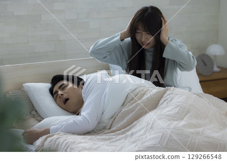 一個年輕人在床上睡覺打呼嚕 一個年輕人在床上睡覺打呼嚕 129266548