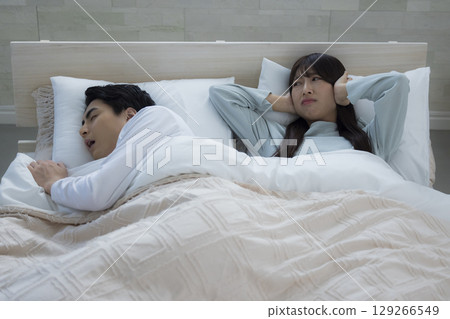 一個年輕人在床上睡覺打呼嚕 一個年輕人在床上睡覺打呼嚕 129266549