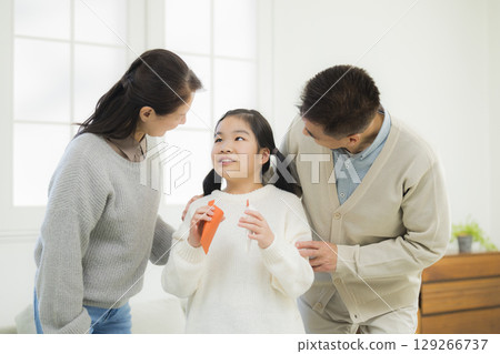 Elementary school student receiving pocket money from grandparents Elementary school student receiving pocket money from grandparents 129266737