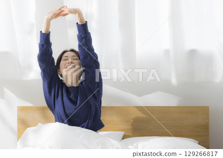 A woman stretching in bed 129266817