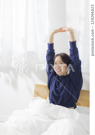 A woman stretching in bed A woman stretching in bed 129266823