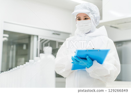 一家水廠和飲料製造商(飲料製造商)身穿防塵服的生產工作人員正在檢查瓶裝水 一家水廠和飲料製造商(飲料製造商)身穿防塵服的生產工作人員正在檢查瓶裝水 129266849