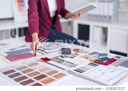 Adult Asian interior design architect professional selecting fabric color material samples for home blueprint planning new project office workspace Adult Asian interior design architect professional selecting fabric color material samples for home blueprint planning new project office workspace 129267227