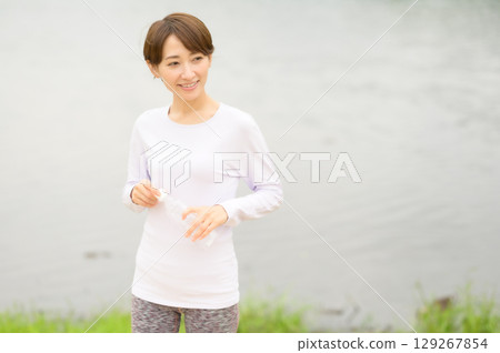 A woman holding a plastic bottle to hydrate after exercise A woman holding a plastic bottle to hydrate after exercise 129267854