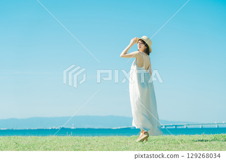 A woman in a dress enjoying vacation at a resort A woman in a dress enjoying vacation at a resort 129268034