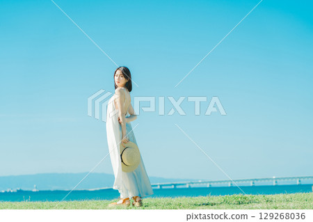 A woman in a dress enjoying vacation at a resort 129268036
