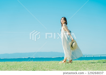 A woman in a dress enjoying vacation at a resort 129268037
