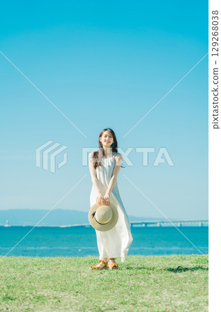 A woman in a dress enjoying vacation at a resort A woman in a dress enjoying vacation at a resort 129268038