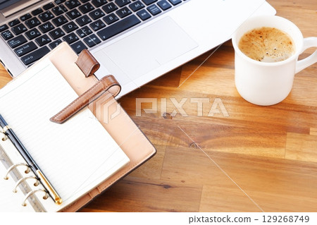 影像顯示,一名工作人員在辦公桌前工作,打開環形系統整理器,喝著咖啡(拿鐵咖啡),在電腦前進行案頭工作 影像顯示,一名工作人員在辦公桌前工作,打開環形系統整理器,喝著咖啡(拿鐵咖啡),在電腦前進行案頭工作 129268749