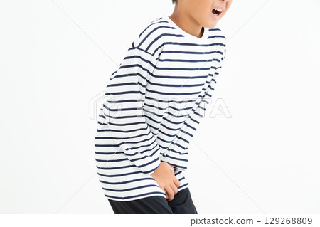 Elementary school boy holding his crotch to hold in his pee 129268809