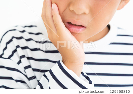 Elementary school boy suffering from tooth decay 129268810