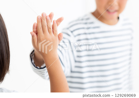 Elementary school boy high-fiving with friends 129269069