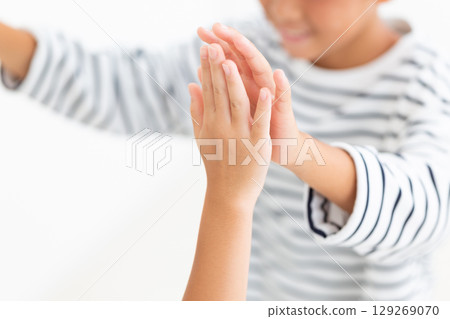 Elementary school boy high-fiving with friends 129269070