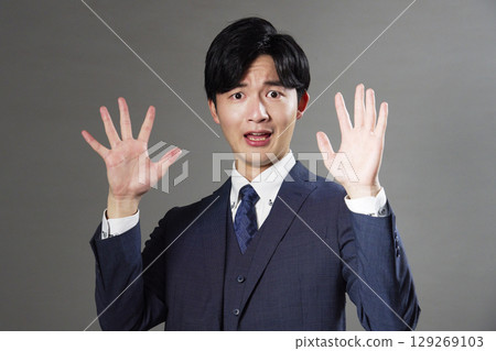 Surprised businessman black background 129269103