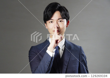 Businessman secret pose black background 129269104