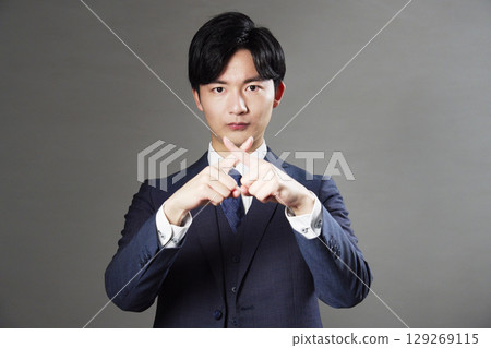 商人在黑色背景上做十字手勢 129269115