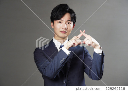商人在黑色背景上做十字手勢 129269116